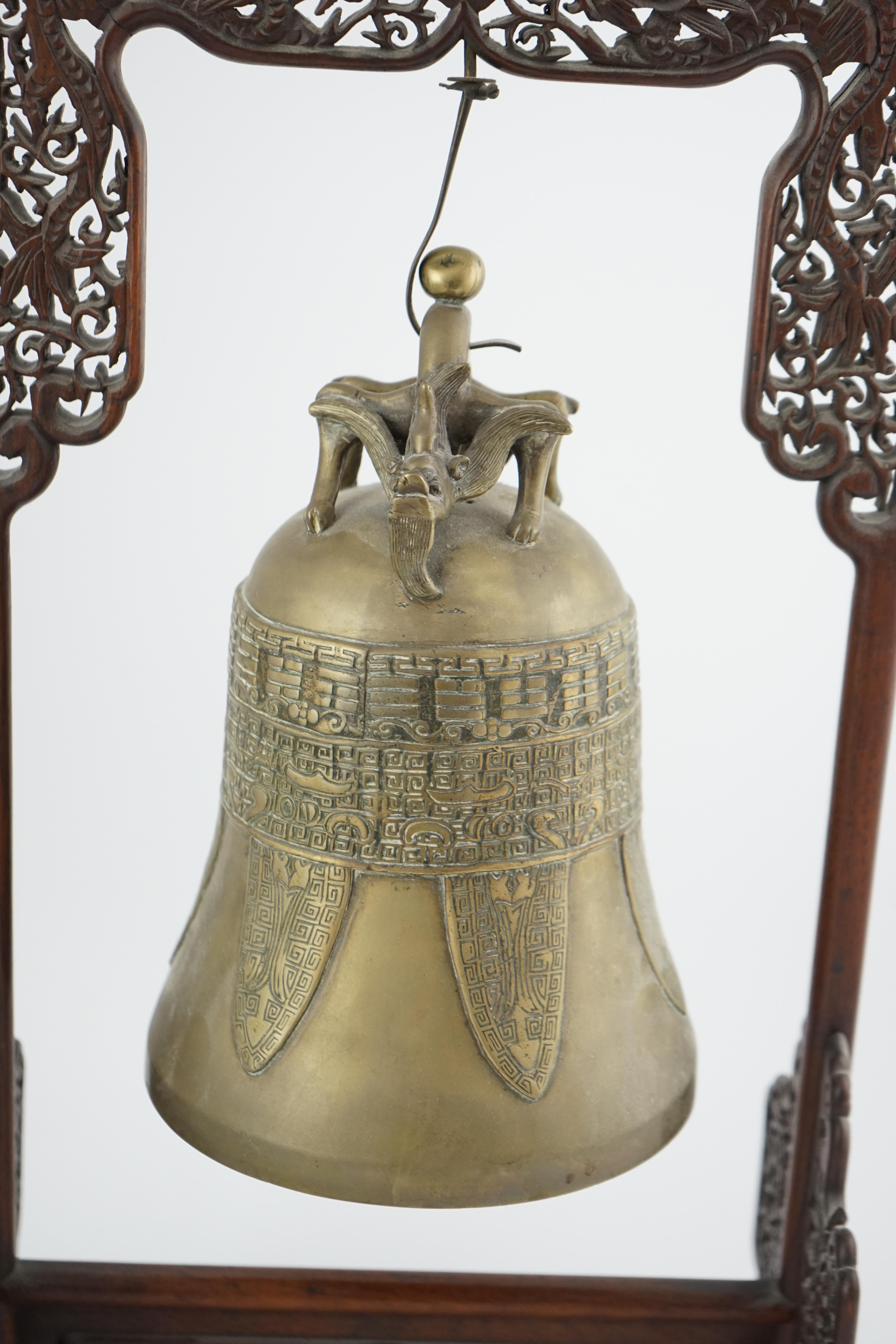 A Chinese archaistic bronze temple bell, and reticulated hardwood stand, Qing dynasty